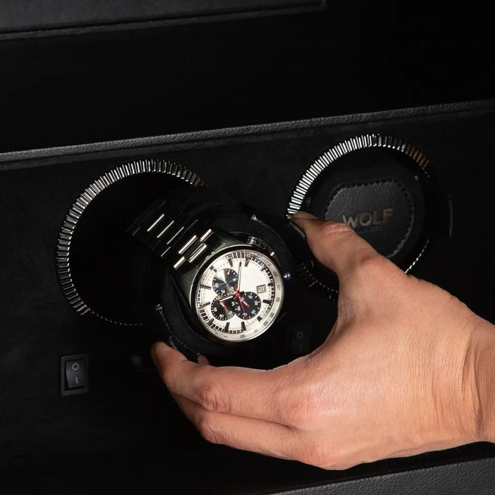 hand placing a watch in its watch winder