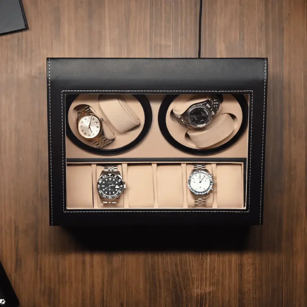 Black leather watch winder with glass lid, 4 rotors for automatic watches and 6 beige interior storage slots.