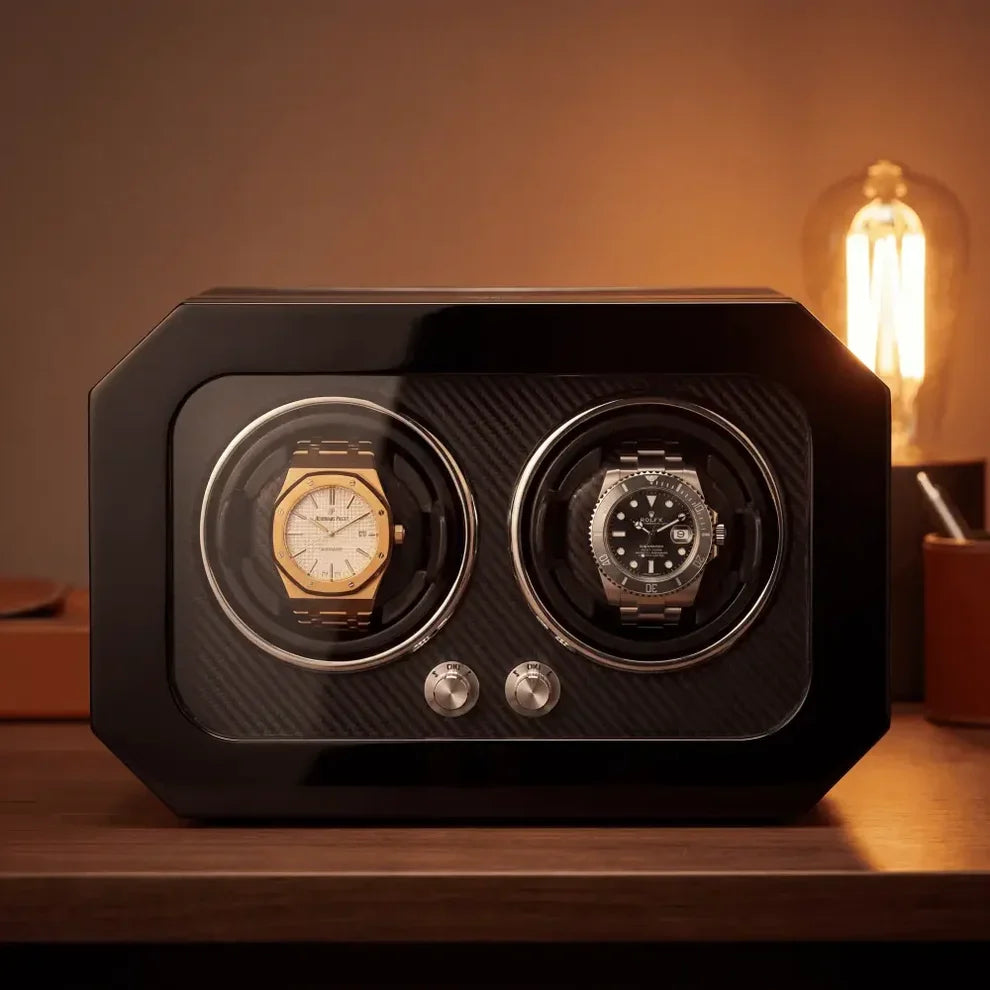 Black carbon fibre watch winder for two automatic watches with a glass front and silver control buttons.
