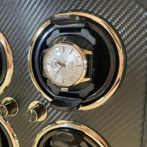 Black carbon fibre Gioco Carbone automatic watch winder with a Seiko watch fitted in a rotating slot.