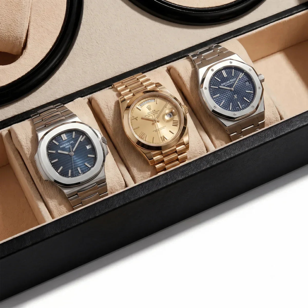 Black leather winder box with beige interior, displaying three luxury watches on suede cushions.