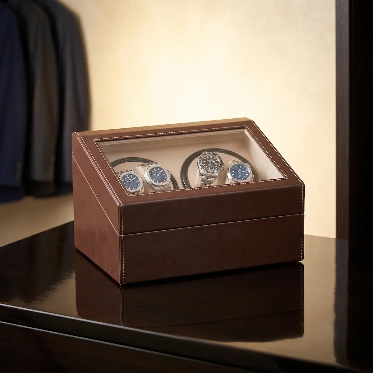 Brown leather watch winder with glass lid, 4 motorised slots and beige suede interior for automatic watches.