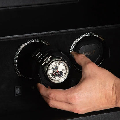 hand placing a watch in its watch winder