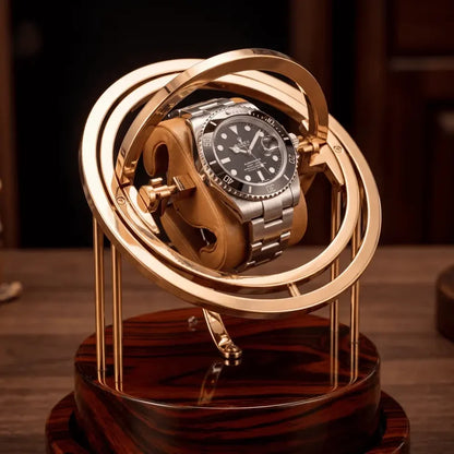 Gold Astronome Prestige watch winder with rotating metal structure and dark wood base for one automatic watch.