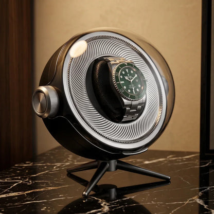 Tripode Solo black watch winder with a transparent dome, holding an automatic watch on an elegant tripod.