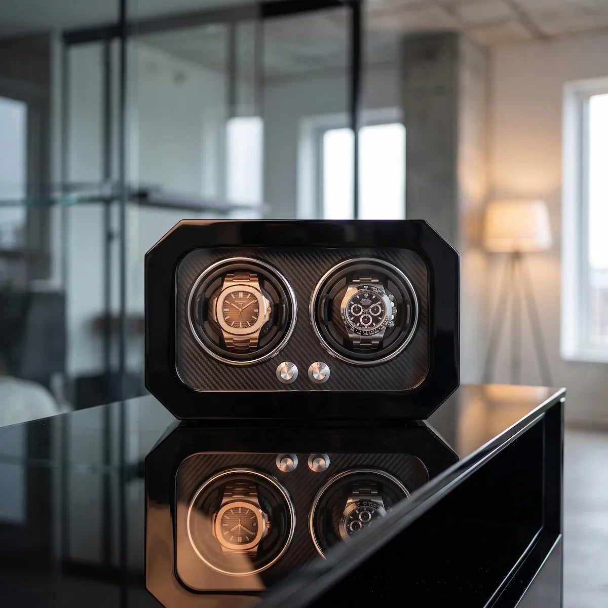 Black carbon fibre watch winder for 2 watches with LED lighting, modern and elegant design placed on a table.
