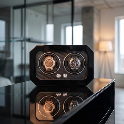 Black carbon fibre watch winder for 2 watches with LED lighting, modern and elegant design placed on a table.
