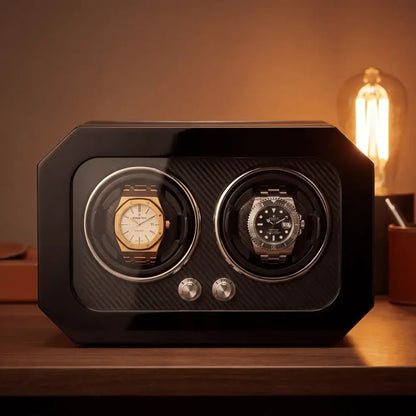Black carbon fibre watch winder for two automatic watches with a glass front and silver control buttons.