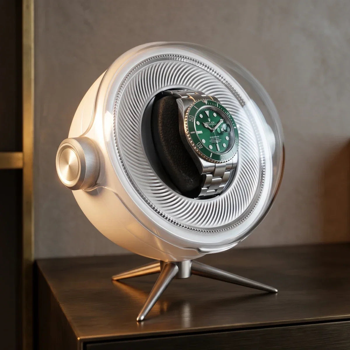 Tripode Solo white automatic watch winder with a modern spherical design and a green-dial watch on its holder.